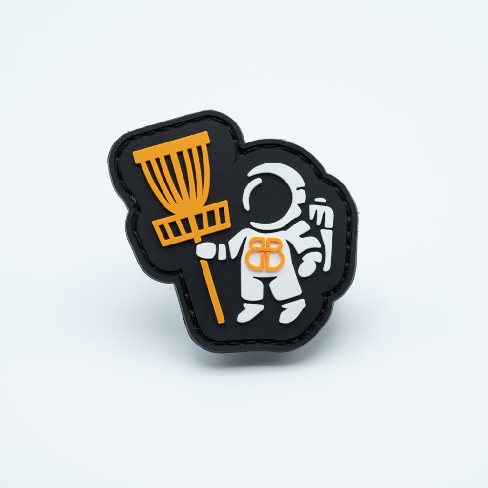 PVC disc golf patch with an astronaut holding a disc golf basket