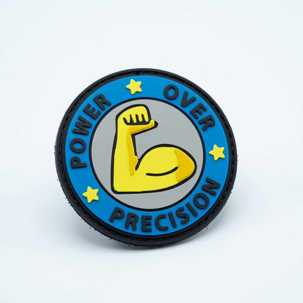 Discgolf patch in PVC with a big arm in the middle and the text Power Over Precision around it