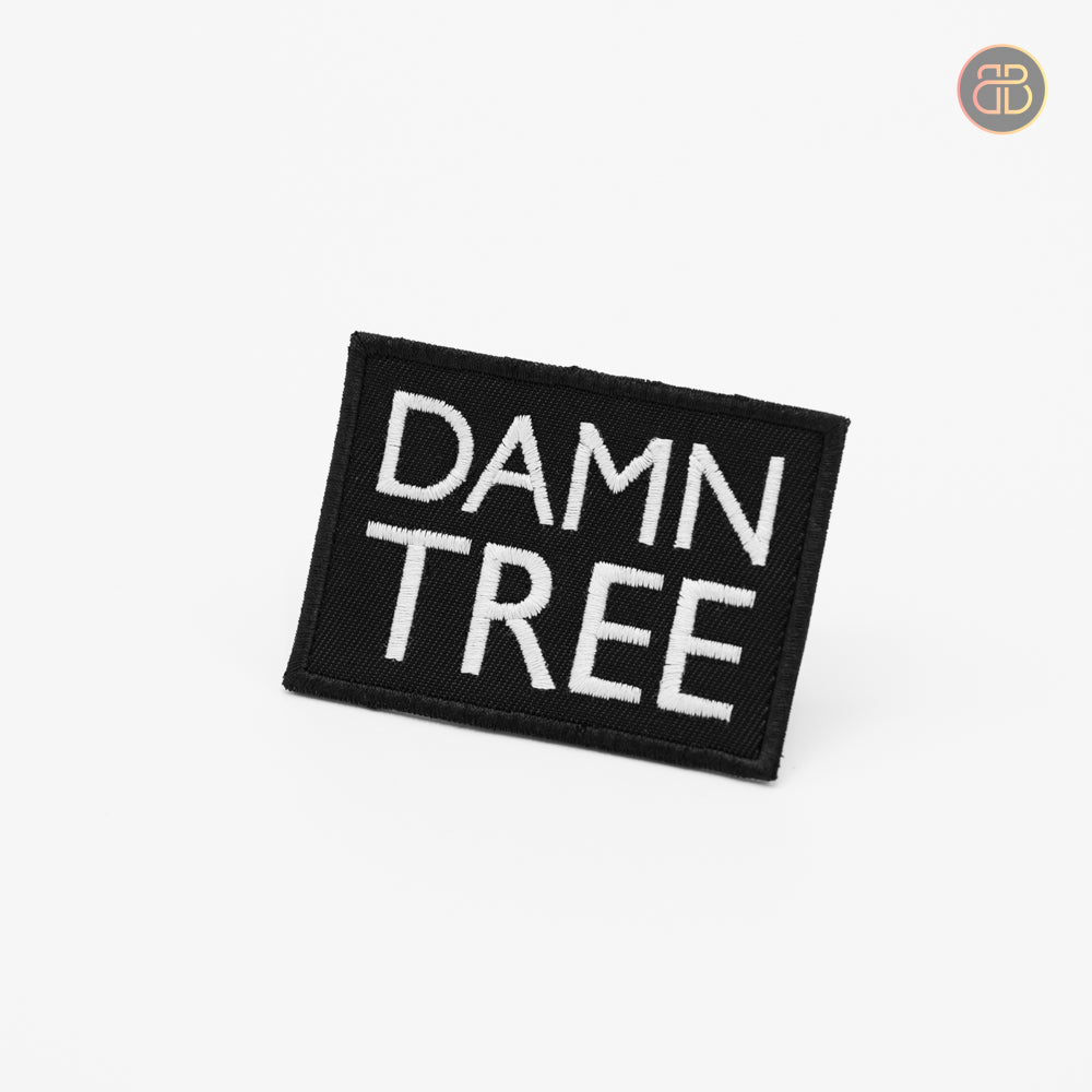 Discgolf patch in black with the text DAMN TREE in white