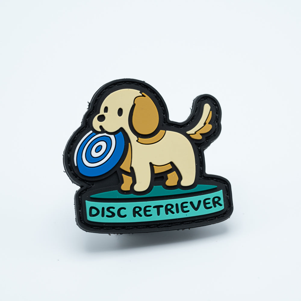Disc golf patch in pvc with a dog holding a disc golf disc in his mouth with the text disc retriever