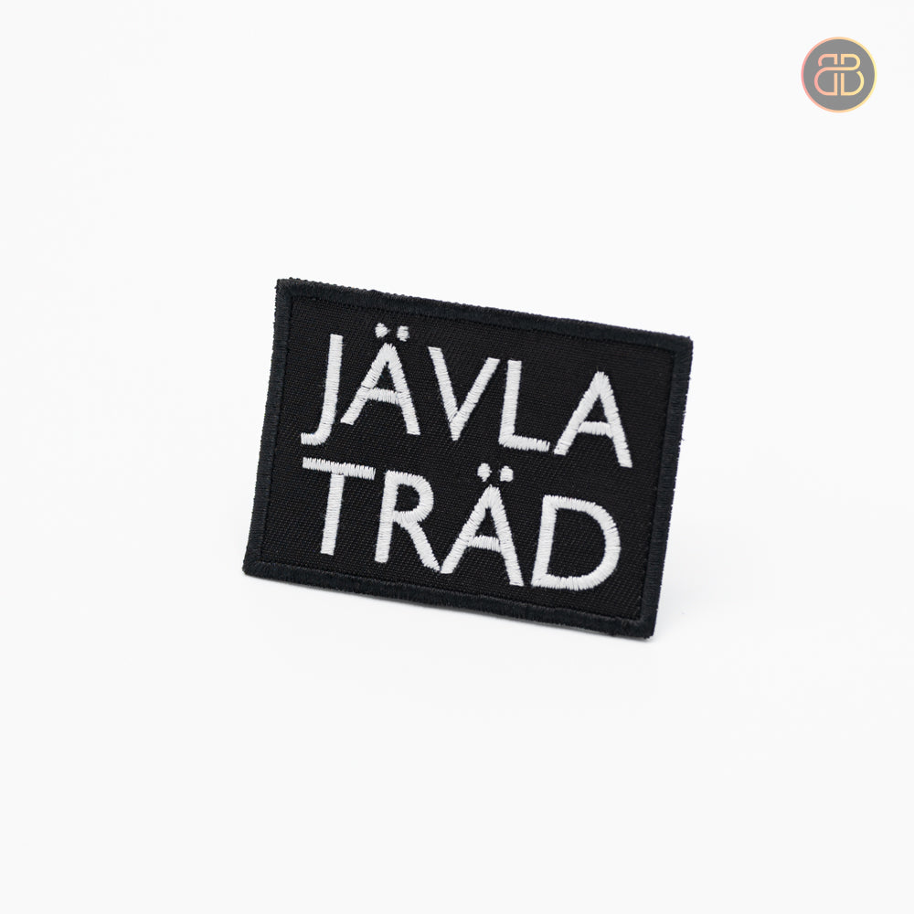 Discgolf patch in black with the text Jävla Träd in white