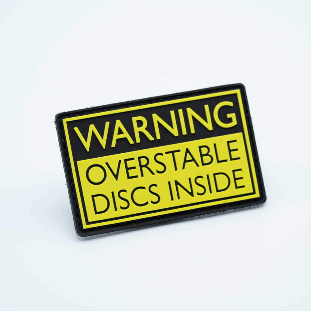 Discgolf patch in pvc with the text Warning Overstable discs inside