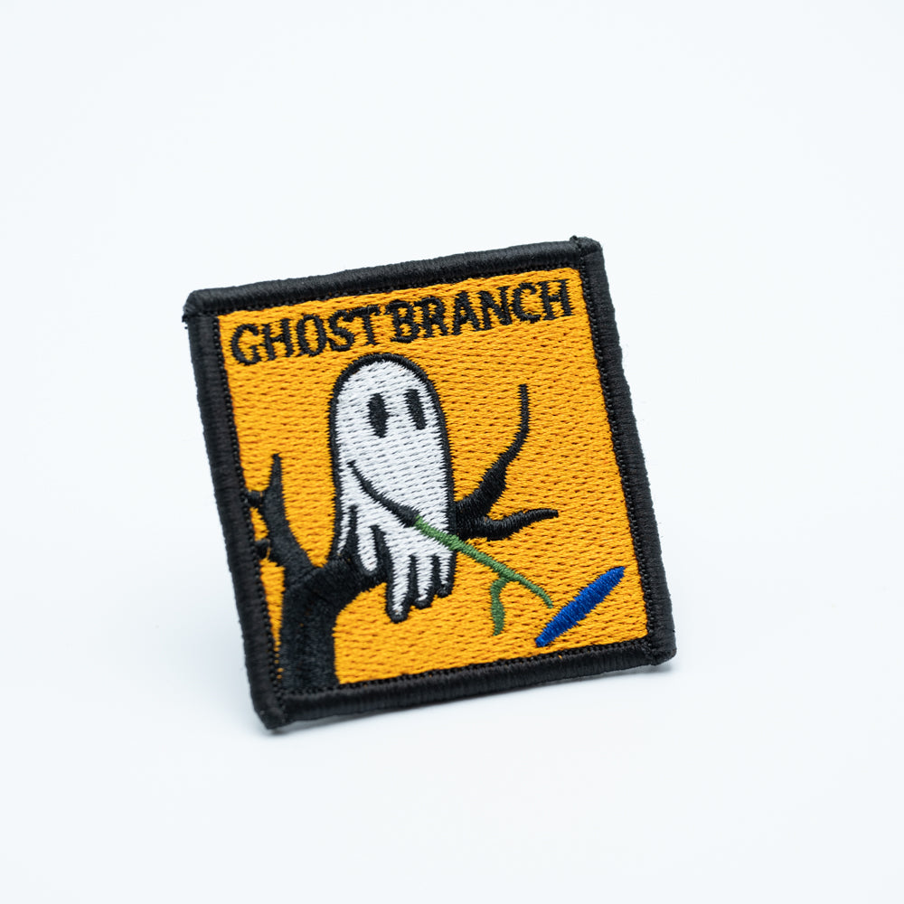 Discgolf patch with the text Ghost Branch and a cartoon moving a dicsgolf disc with a stick