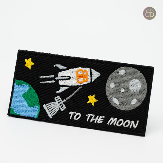 Discgolf patch showing a rocket leaving earth moving towards the moon