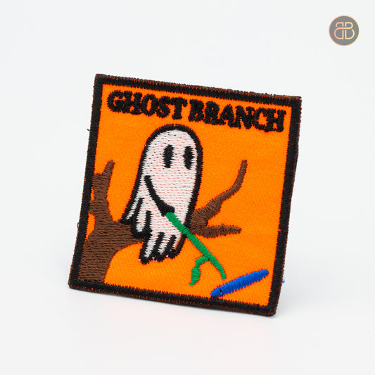 Discgolf patch with the text Ghost Branch and a cartoon moving a dicsgolf disc with a stick